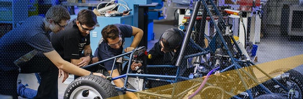 Students working on a mini Kart vehicle